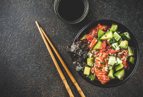 Asian trendy food, sushi poke bowl with cucumber, salmon, avocado, Black and White Sesame Seeds